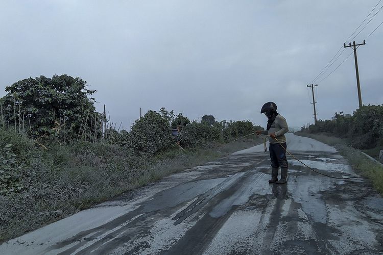 Warga membersihkan jalan yang dipenuhi debu vulkanik pasca erupsi Gunung Sinabung, di Desa Sigarang-garang, Karo, Sumatera Utara, Sabtu (8/8/2020). Gunung Sinabung erupsi dengan tinggi kolom 2.000 meter. ANTARA FOTO/Sastrawan Ginting/Lmo/hp.
