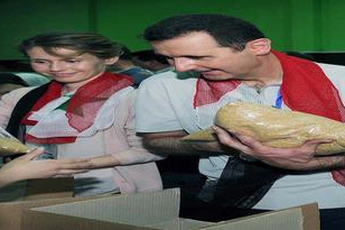 Presiden Suriah Bashar al-Assad and istrinya Asma, bergabung dengan para relawan dalam menyiapkan paket bantuan pangan untuk warga Homs, di Stadion Al-Fahya, Damaskus, Senin (16/4/2012). Homs saat ini masih terus digempur militer Suriah.
