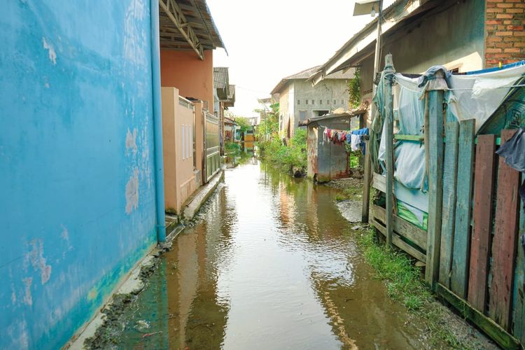 Jalan dan halaman rumah warga yang kebanjiran pasca pascapenimbunan lokasi pembangunan Islamic Center di Kelurahan Tangkahan, Kecamatan Medanlabuhan, Rabu (23/11/2022).