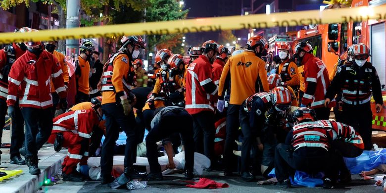 Petugas penyelamat dan pemadam kebakaran bekerja di lokasi tragedi Halloween Itaewon. Seoul, Korea Selatan, Sabtu (29/10/2022). Sedikitnya 149 orang tewas setelah mengalami serangan jantung, sesak napas akibat berhimpitan di gang sempit dan jalan berliku bersama ribuan orang.
