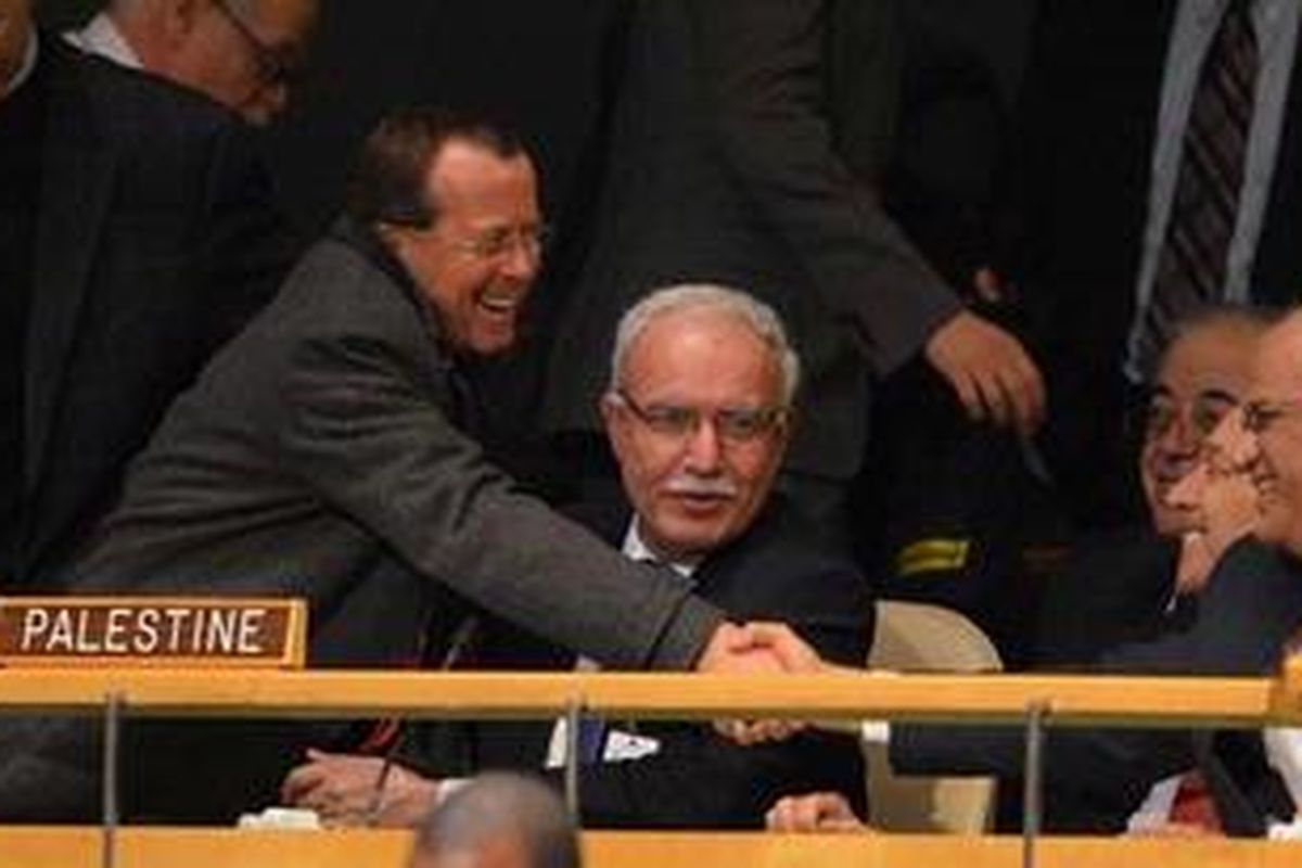 Seorang anggota delegasi memberi selamat kepada delegasi Palestina setelah hasil voting mendukung resolusi Palestina menjadi negara pemantau non anggota di PBB di Sidang Majelis Umum PBB di New York, AS, Kamis (29/11/2012).