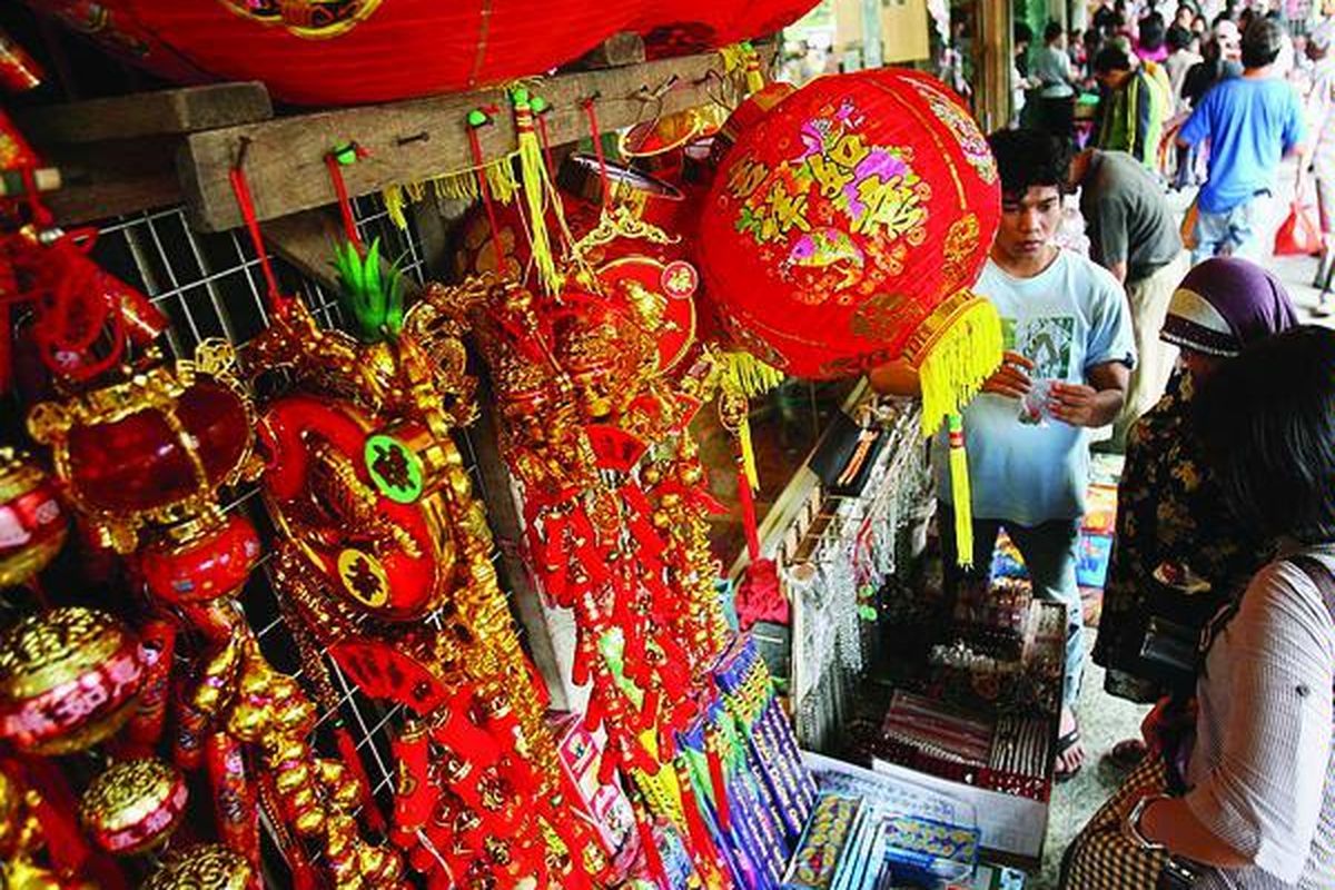 Warga berbelanja pernak- pernik imlek yang dijual pedagang di Jalan Pancoran, Glodok, Jakarta Barat, Jumat (12/2). Selain pernik imlek, di lokasi tersebut juga menjual berbagai kue dan penganan untuk Imlek.