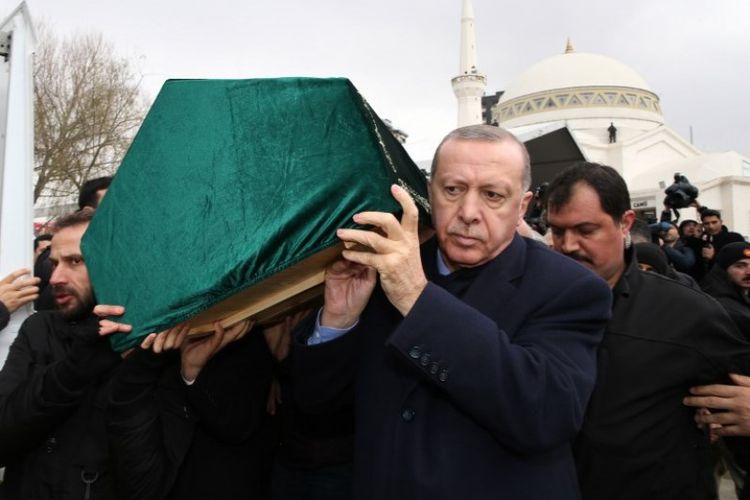 Presiden Turki Recep Tayyip Erdogan (kanan) pada Sabtu (9/2/2019) mengangkat peti jenazah korban tewas apartemen runtuh di Istabul, Turki. (AFP/TURKISH PRESIDENTIAL PRESS SERVICE)