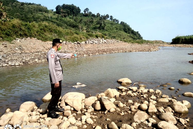 Seorang polisi menunjuk titik dimana Rehan tenggelam di Sungai Waung di Desa Ringinrejo, Kecamatan Wates, Kabupaten Blitar, Rabu (11/5/2022)