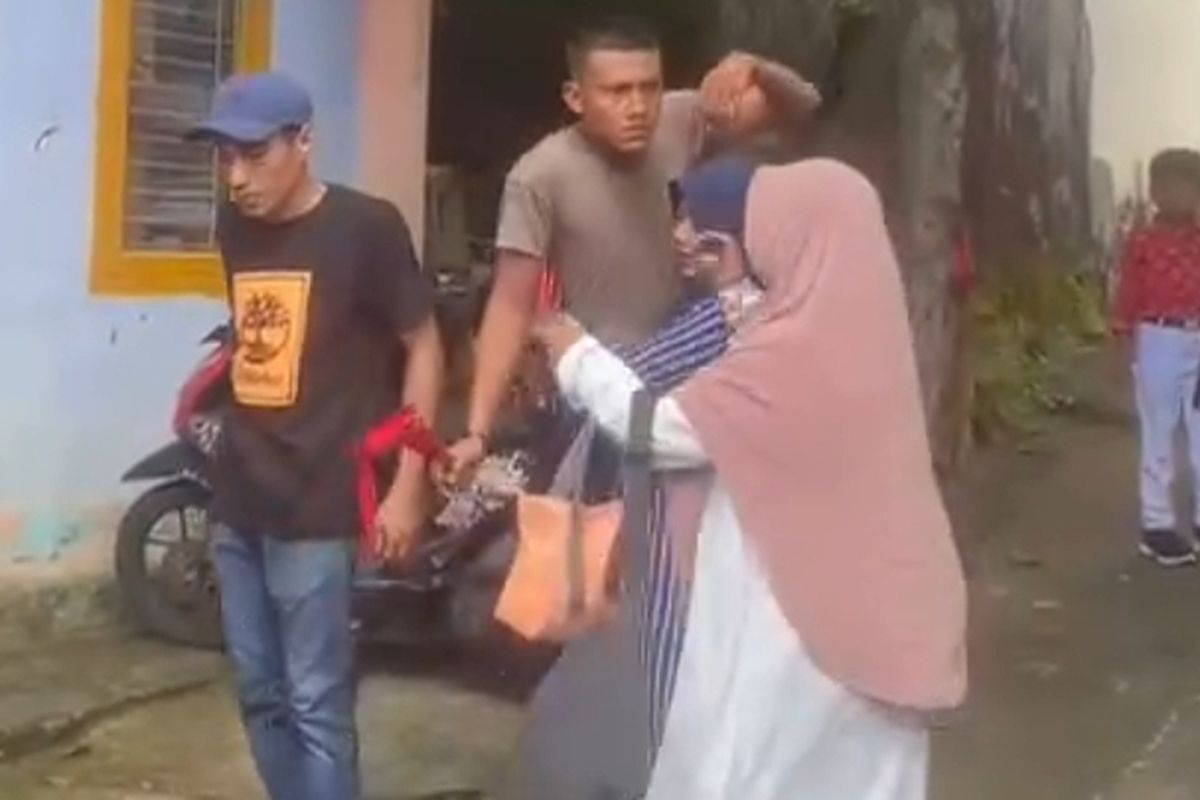 Oknum polisi yang mengamuk dan membawa sajam di sebuah sekolah dasar di Ternate, saat dilerai sejumlah orang.