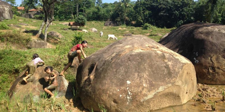 Anak-anak bermain lumpur dan menaiki batuan andesit di tengah persawahan kaki Gunung Parang, di Kampung Cisaga, Desa Sukamulya, Kecamatan Tegalwaru, Purwakarta, Minggu (2/7/2017). 