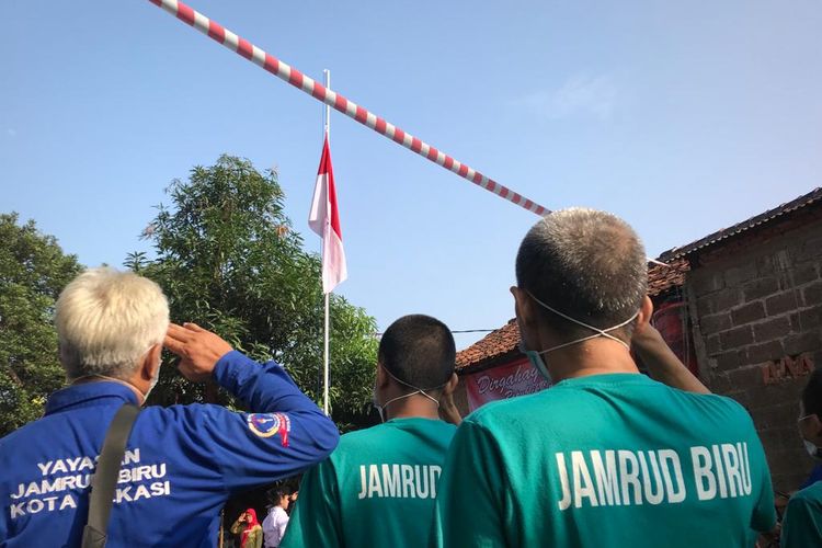 Pasien ODGJ didampingi oleh perawat (berbaju baru) dari Yayasan Jamrud Biru yang ikut dalam prosesi pengibaran bendera Sang Saka Merah Putih saat perayaan HUT Republik Indonesia ke 77 di Mustikasari, Kecamatan Mustika Jaya, Kota Bekasi, Rabu (17/8/2022).