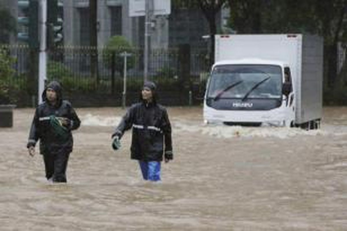 Warga melintasi banjir di Jakarta Pusat, Senin (9/2/2015). Curah hujan yang tinggi mengakibatkan sejumlah tempat di ibu kota terendam banjir.