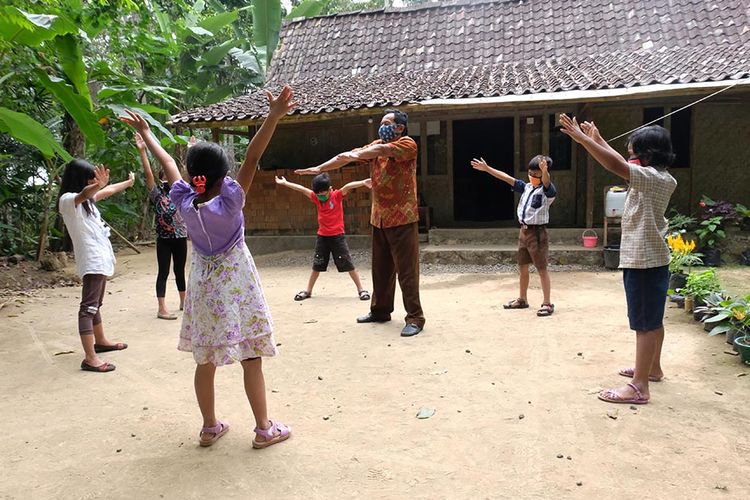 Foto dirilis Selasa (18/8/2020), memperlihatkan guru SD Kanisius Kenalan Henricus Suroto (tengah) mengajari pola hidup sehat kepada murid-muridnya dengan berolah raga di halaman rumah warga sebagai salah satu upaya mencagah penyebaran Covid-19. Demi berlangsungnya pendidikan untuk siswanya selama pandemi Covid-19, Suroto mengunjungi rumah murid untuk melakukan pembelajaran tatap muka dengan tetap menerapkan protokol kesehatan.