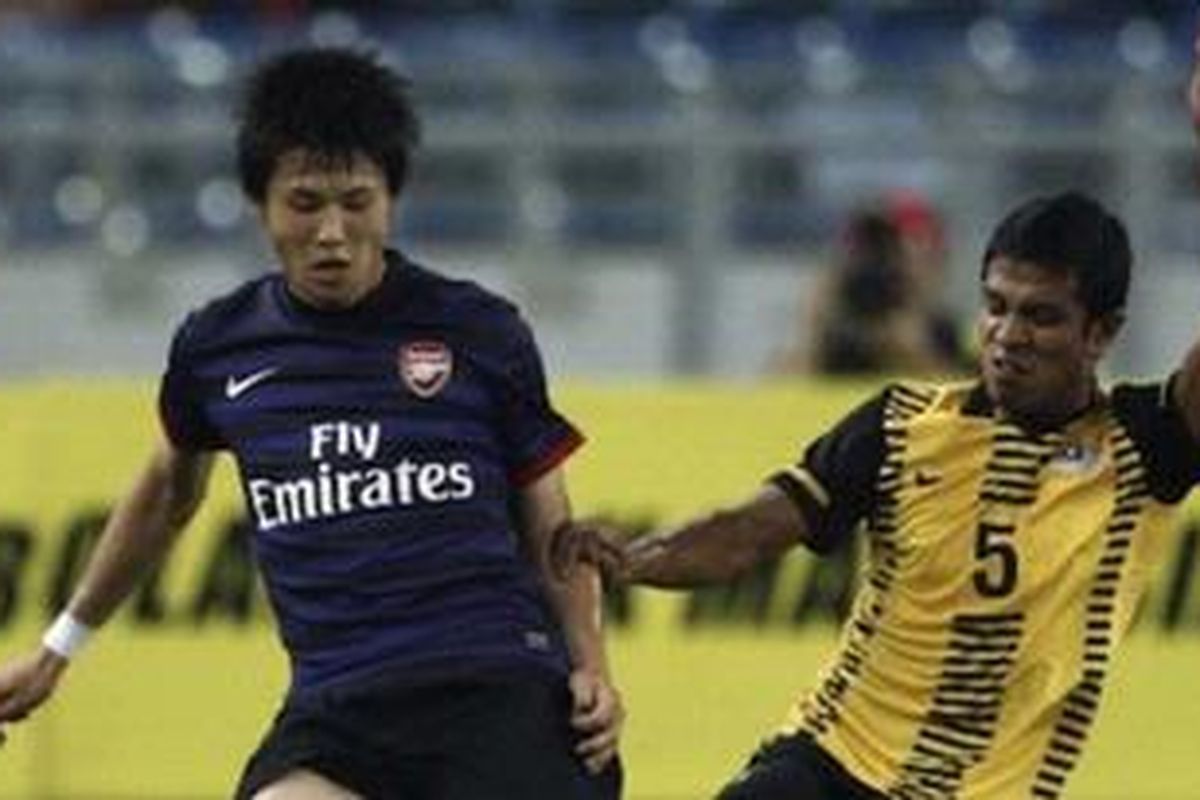 Penyerang sayap Arsenal, Ryo Miyaichi berjibaku melawan Malaysia XI di Stadion Bukit Jalil, Malaysia, Selasa (24/7/2012).