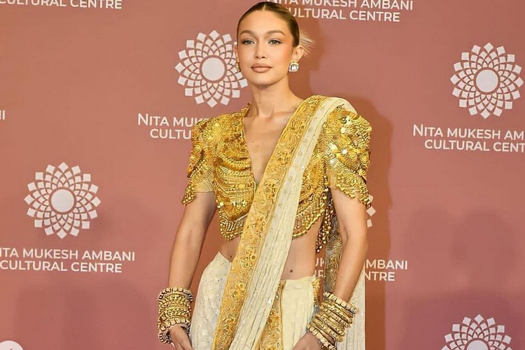 Gigi Hadid mengenakan sari India bernuansa keemasan dalam acara Nita Mukesh Ambani Cultural Centre (NMACC) di Mumbai.