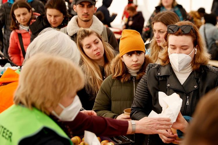 Tim relawan membagikan makanan kepada pengungsi dari Ukraina yang tiba di Berlin, Jerman.