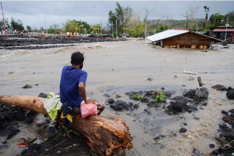 Seorang pria memandangi sebuah rumah yang terendam banjir yang disebabkan oleh hujan lebat akibat Topan Goni di Provinsi Albay, Filipina, Minggu (1/11/2020).