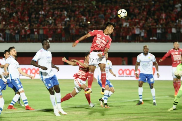 Pemain Bali United, I Nyoman Sukarja, menyundul bola di dalam area pinalti Persib Bandung.