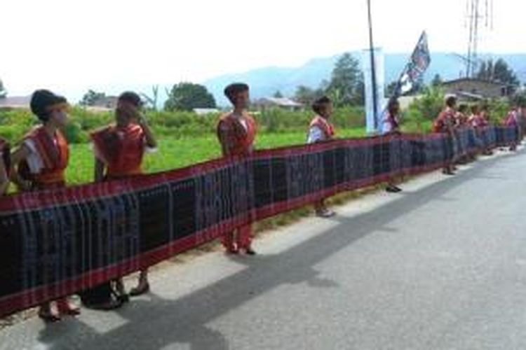 Ratusan siswa SMA 1 Balige, Toba Samosir, Sumatera Utara berjejer di sepanjang Jalan TB Silalahi Center yang menjadi lokasi pembukaan Festival Danau Toba 2014 untuk membentangkan ulos sadum sepanjang 500 meter.  
