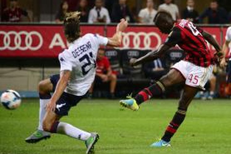 Penyerang AC Milan Mario Balotelli (kanan) melepaskan tembakan yang berujung gol ke gawang Cagliari, pada laga Serie-A, di San Siro, Minggu (1/9/2013).