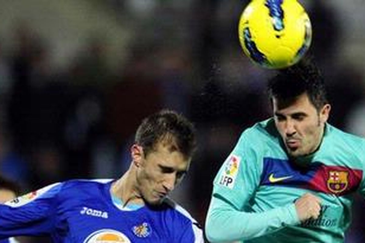 Penyerang Barcelona, David Villa (kanan), berebut bola dengan bek Getafe, Juan Valera, pada pertandingan Liga BBVA, di Alfonso Perez, Sabtu (26/11/2011).