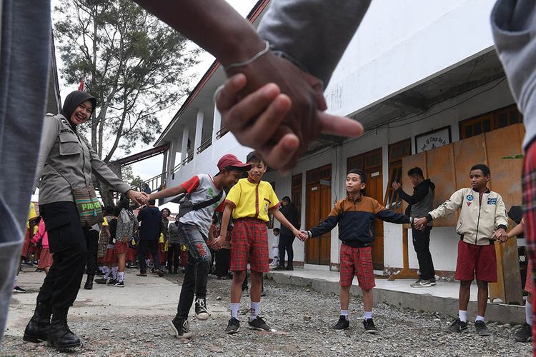 Seorang anggota Polisi wanita bermain dengan siswa SD Triesa Unggul Terpadu di Kota Wamena, Kabupaten Jayawijaya, Papua, Rabu (9/10/2019). Aktivitas di sejumlah sekolah Kota Wamena masih berfokus pada pemulihan trauma pada siswa pascaaksi unjuk rasa yang berujung anarkis pada 23 September 2019 lalu.
