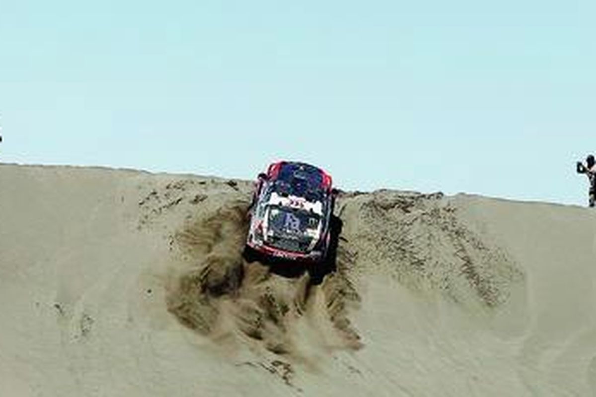 Pereli Opel asal Hongaria Balazs Szalay dan co-driver Laszlo Bunkoczi merayap menaiki tanjakan di etape kedua Reli Dakar antara Santa Rosa de la Pampa dan San Rafael di  Argentina, Senin (2/1).