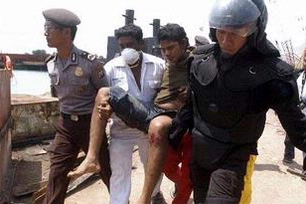 Petugas mengevakuasi pekerja asal India yang terluka diamuk massa buruh galangan kapal PT Drydocks World Graha di Tanjung Uncang, Batam, Kamis (22/4/2010).