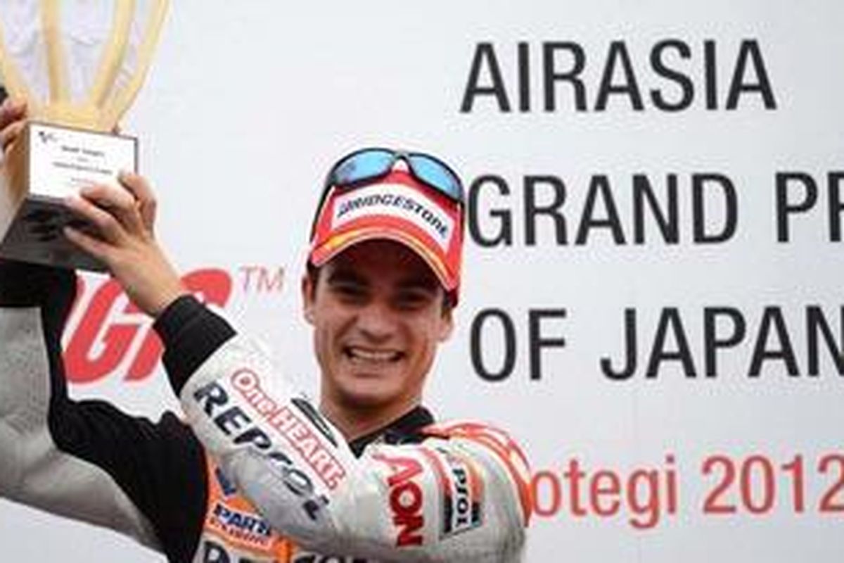 Pebalap Repsol Honda, Dani Pedrosa, mengangkat trofi kemenangan yang diraih di Motegi, Jepang, Minggu (14/10/2012).