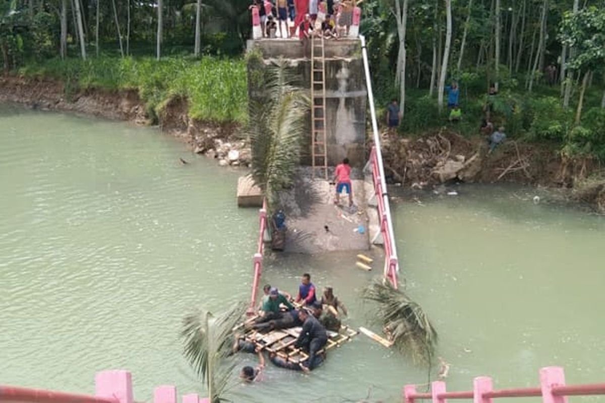 Sejumlah warga melakukan evakuasi terhadap salah satu korban jembatan ambruk di Pacitan Jawa Timur, pada Minggu, (04/12/2022).