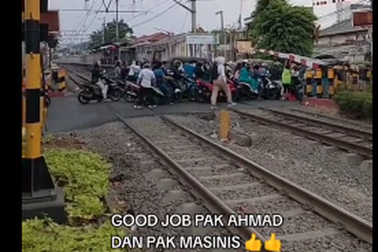 Tangkapan layar video yang merekam kereta api harus berhenti karena ada kerumunan kendaraan di perlintasan sebidang
