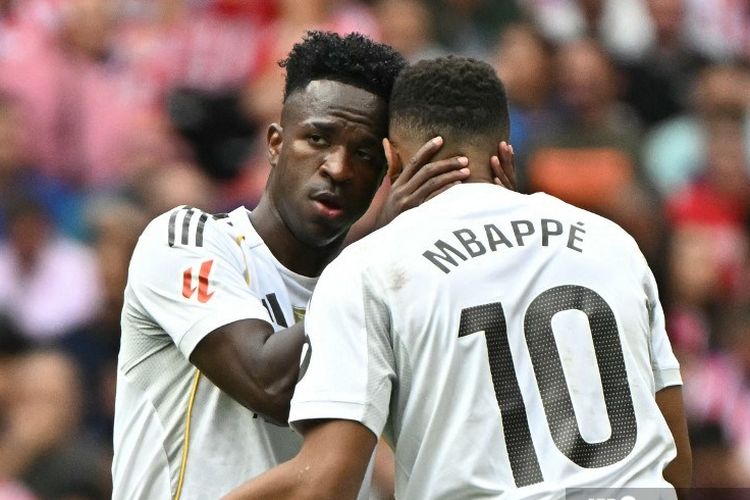 Penyerang Real Madrid, Kylian Mbappe, merayakan gol bersama Vinicius Junior saat mencetak gol pertama timnya pada laga Liga Spanyol Atletico Madrid vs Real Madrid di stadion Metropolitano di Madrid pada 27 September 2025.