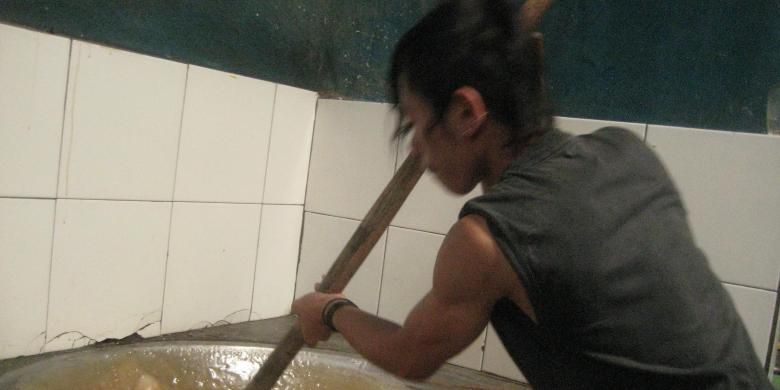 Suryana, salah seorang pekerja perusahaan dodol garut milik Haji Uyud di Kampung Ngamplang, Kelurahan Desa Kolot, Kecamatan Cilawu, Kabupaten Garut, Jawa Barat  mengolah adonan bahan dodol pada Sabtu (16/4/2016). Butuh waktu empat jam mengaduk agar adonan betul-betul menjadi dodol siap saji.  