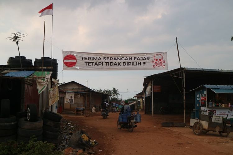 Warga Kampung Nenas, Kelurahan Teluk Tering, Kecamatan Batam Kota, terlihat membentangkan spanduk yang bertuliskan Terima Serangan Fajar, Tetapi Tidak Dipilih.