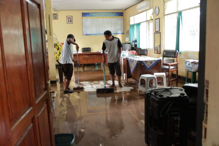 Foto:Para guru di SMPN 1 Banyuglugur ketika membersihkan air dan lumpur di rungan guru pada Rabu (1/3/2023)