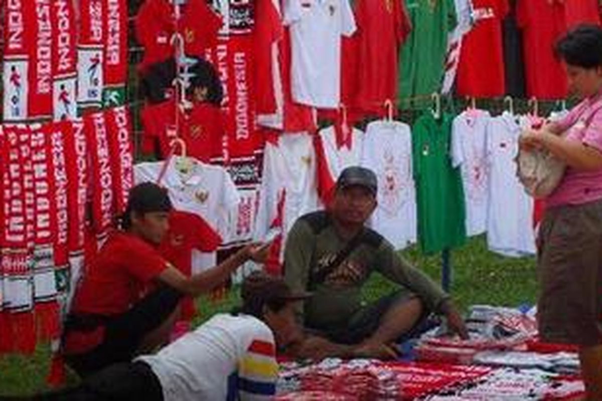 Pedagang musiman menjajakan dagangan kaos Tim Nasional Indonesia di kawasan Stadion Gelora Bung Karno, Senayan, Jakarta Selatan, Sabtu (4/12/2010). Para pedagang kaos timnas Indonesia bergantung pada kemenangan tuan rumah Indonesia agar dagangan mereka laku. Harga kaos di jual bervariasi antara Rp 20.000 hingga Rp 40.000.