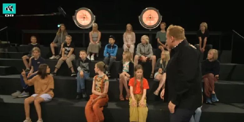 Pemandu acara Ultra Strips Down, Jannick Schow, ketika berbincang bersama sejumlah peserta anak-anak. Acara TV di Denmark itu menjadi sorotan karena menunjukkan orang bugil di depan anak kecil.