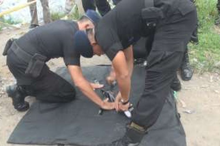 Personel Brimob Polda Sumsel mengamankan temuan sebuah granat nanas di Desa Tanjung Pering Ogan Ilir Sumsel