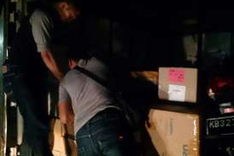 Polisi saat menggeledah isi truk yang membawa barang ilegal yang diselundupkan dari Malaysia.