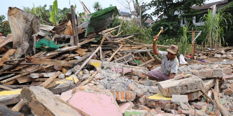 Warga membongkar rumahnya sendiri sebelum ditertibkan di area bantaran aliran Sungai Ciliwung di RW 01 Bukit Duri, Jakarta Selatan, Selasa (11/7/2017). Setelah bangunan diratakan dengan tanah, Balai Besar Sungai Ciliwung Cisadane (BBWSCC) akan memulai memasang sheet pile sebagai lanjutan proyek normalisasi Ciliwung.
