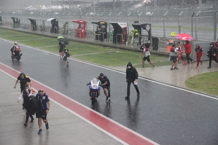 Para pembalap dan kru kembali ke lapangan di tengah hujan lebat yang mengguyur area sirkuit Mandalay jelang Race 1 World Superbike Class, Sabtu (20/11/2021).