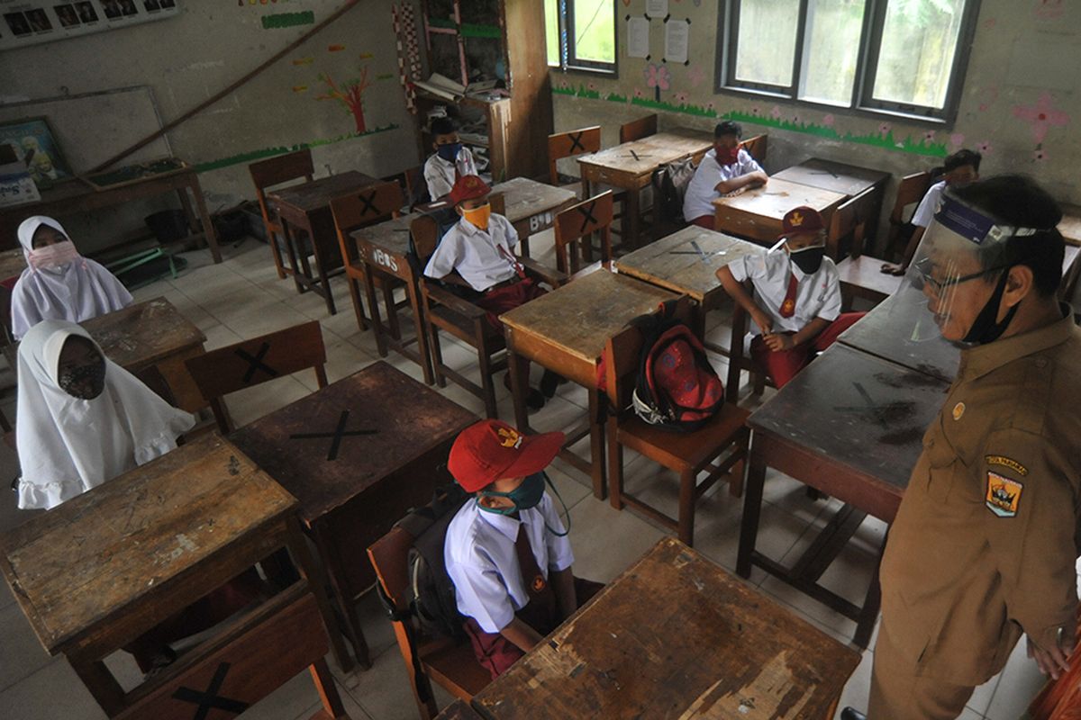 Guru memberikan pengarahan kepada murid saat hari pertama masuk sekolah di SDN 11 Marunggi, Pariaman, Sumatera Barat, Senin (13/7/2020). Kota Pariaman bersama Kabupaten Pesisir Selatan, Kota Sawahlunto dan Kabupaten Pasaman Barat merupakan empat daerah di zona hijau di Sumatera Barat yang sudah memulai aktivitas belajar-mengajar di sekolah dengan pola tatap muka langsung dan menerapkan protokol kesehatan COVID-19.