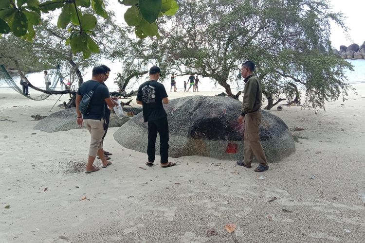 Relawan membersihkan batu granit di Pantai Tanjung Tinggi, Belitung yang sempat jadi sasaran aksi vandalisme, Minggu (7/5/2023).