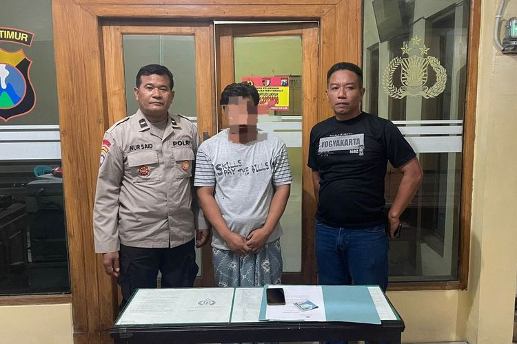 MZ (tengah) terduga pengepul perjudian togel online pada saat diamankan di kantor Polsek Karanggeneng, Lamongan, Jawa Timur.