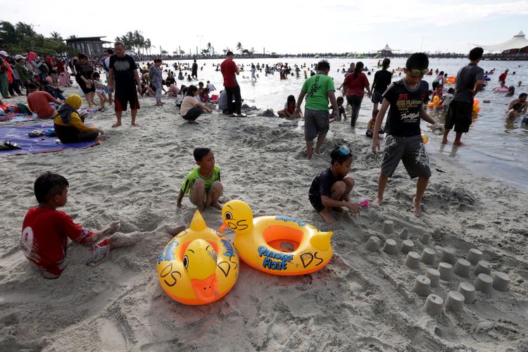 Pengunjung memanfaatkan liburan mengunjungi pantai di kawasan Taman Impian Jaya Ancol, Jakarta, Selasa (27/6/2017). 