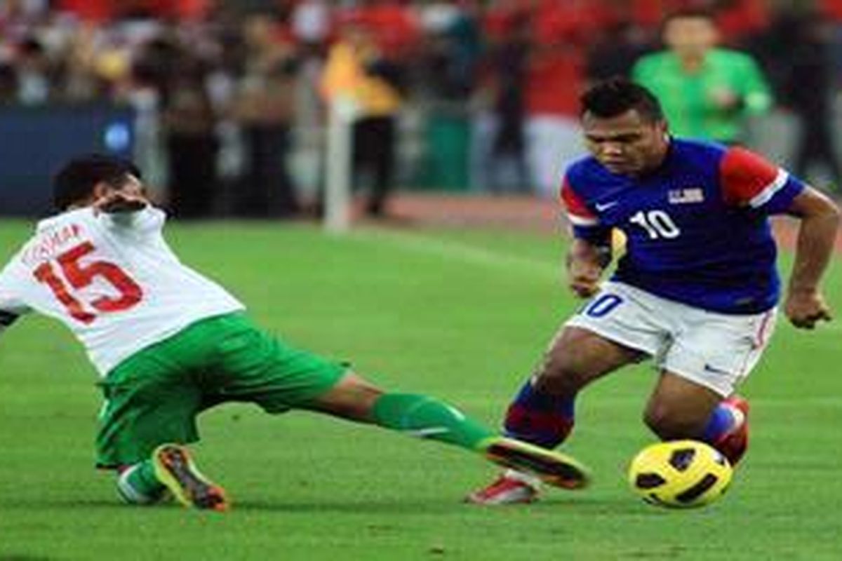 Gelandang Indonesia, Firman Utina, bersusah payah menghadang striker Malaysia, Mohd Safee, Minggu (26/12/2010). Indonesia dibantai 0-3 di laga ini. 