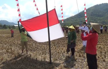 Petani yang bertugas sebagai pngibar bendera merah putih, dalam upacara peringatan hari kemerdekaan RI ke-75 di kawasan persawahan Desa Sambirejo Trenggalek Jawa Timur, Senin (17/08/2020).