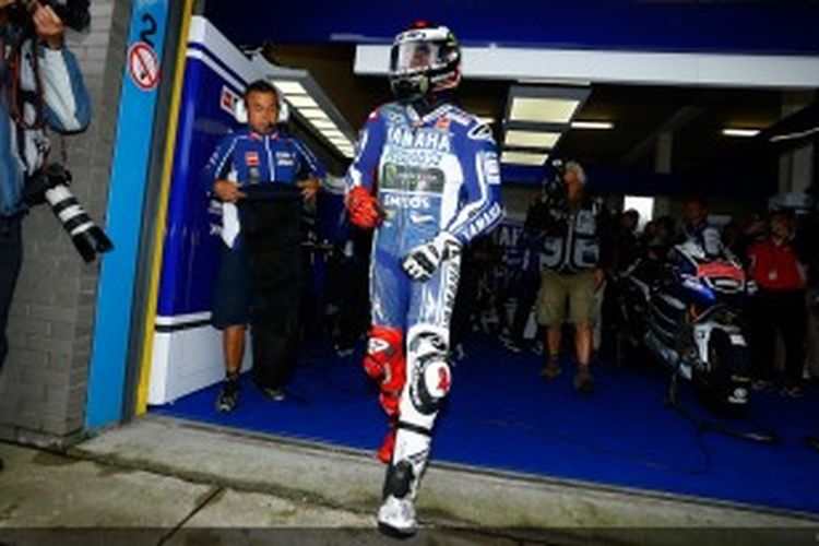 Pebalap Yamaha asal Spanyol, Jorge Lorenzo, berjalan di depan garasi Yamaha di Sirkuit Assen, pada sesi pemanasan GP Belanda, Sabtu (29/6/2013). Lorenzo membalap dengan collarbone kiri yang baru dioperasi, sekitar sehari sebelumnya.