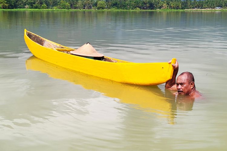 Anton Matani dan perahu kayu kuningnya berada di tengah Danau limboto saat mencari ikan dengan cara menyelam atau dulopo. Cara Dulopo ini sudah banayk ditinggalkan orang
