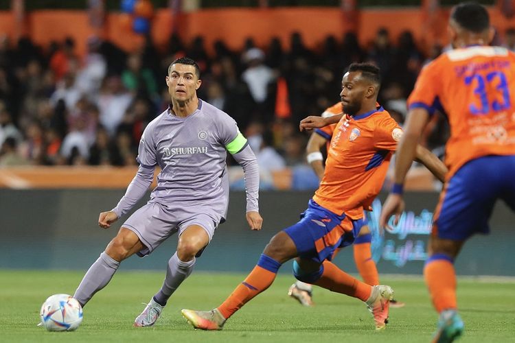 Penyerang Al Nassr Cristiano Ronaldo (kiri) berusaha melewati kawalan pemain Al Feiha. Laga Al Feiha vs Al Nassr dalam lanjutan Liga Arab Saudi musim 2022-2023 berlangsung di Stadion Al-Majmaah pada Senin (10/4/2023) dini hari WIB.