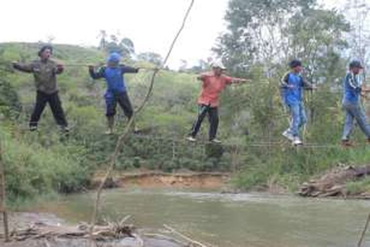 Sejumlah personil Taruna Siaga Bencana (Tagana) Aceh Tengah sedang melintasi jembatan darurat yang terdapat di sekitar sungai Berawang Kunyit, Kecamatan Jagong, Kabupaten Aceh Tengah, Provinsi Aceh. Mereka melintasi jalur tersebut untuk melakukan pencarian tubuh Ade Mauliza, bocah berusia 5 tahun yang diduga hilang diduga terseret arus sungai tersebut, Rabu (13/4/2016).