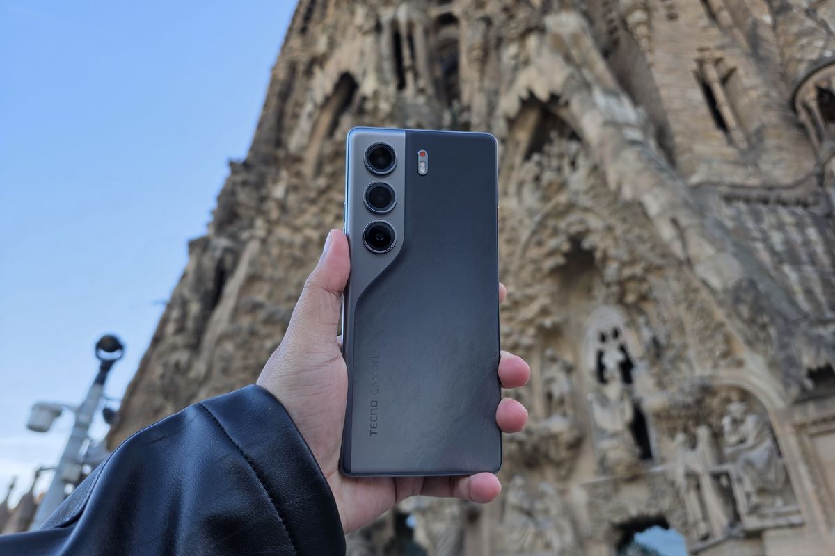 Hands-on Tecno Camon 40 4G varian warna abu-abu di depan Basilika Sagrada Familia, Barcelona, Spanyol.