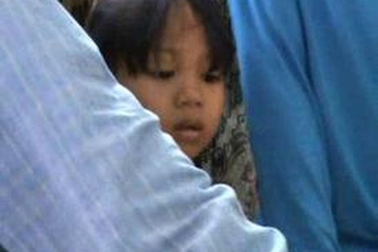 Rini (6), seorang bocah enam tahun berjuang untuk mendapatkan BLSM di kantor pos, lantaran kedua orangtuanya memilih merantau ke Malaysia.