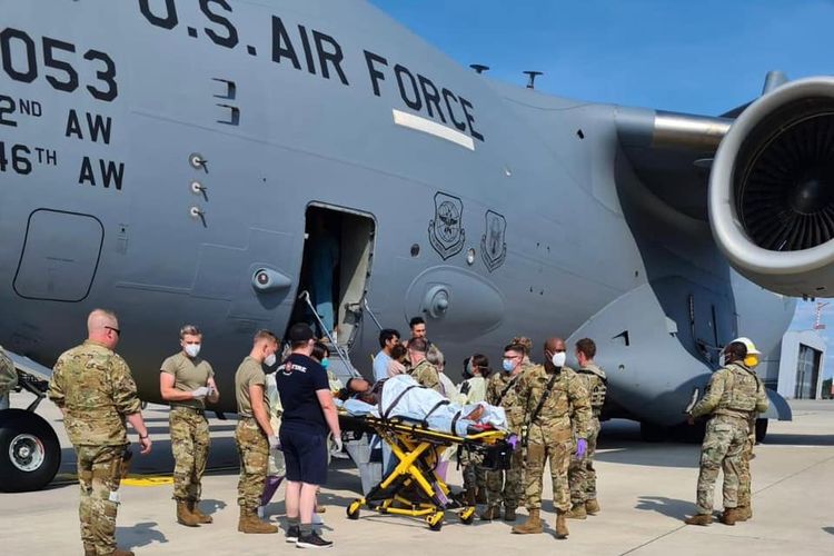 Para staf medis membantu seorang wanita Afghanistan melahirkan bayi di ruang kargo pesawat di Pangkalan Udara Ramstein, Jerman, Minggu (22/8/2021).